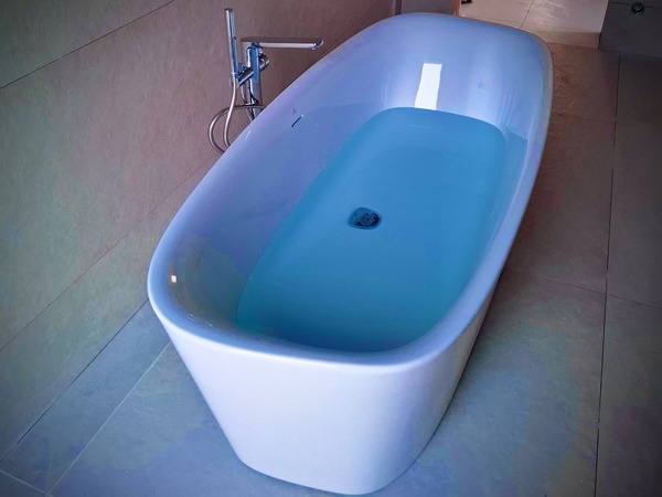 Helles Badezimmer mit freistehender Design-Badewanne und eleganter Armatur, gestaltet von Schiffbauer ECO